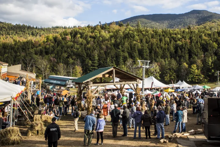 An Oktoberfest event on the lower slopes of a mountain on a sunny fall day.