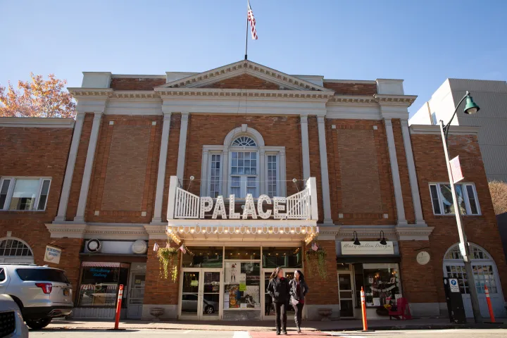 The exterior of a brick movie palace from the 1920s on a sunny fall day.