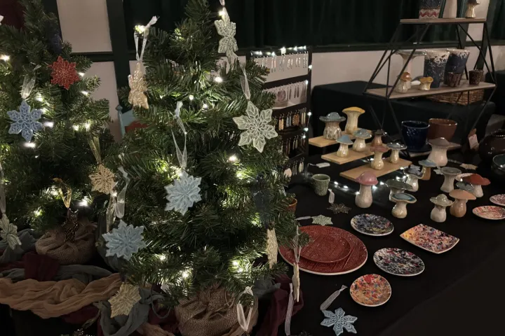 A table of handcrafted pottery ornaments on a table at a craft show.