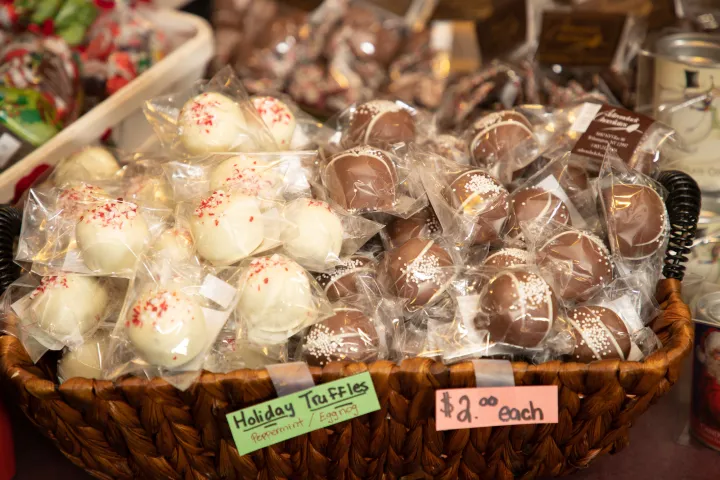 White and milk chocolate truffles packaged for sale at a shop.
