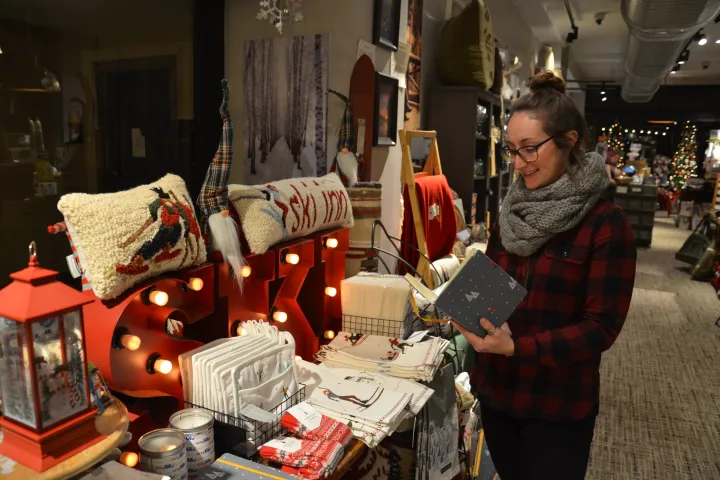 A woman shops for holiday gifts at a market decorated for Christmas.