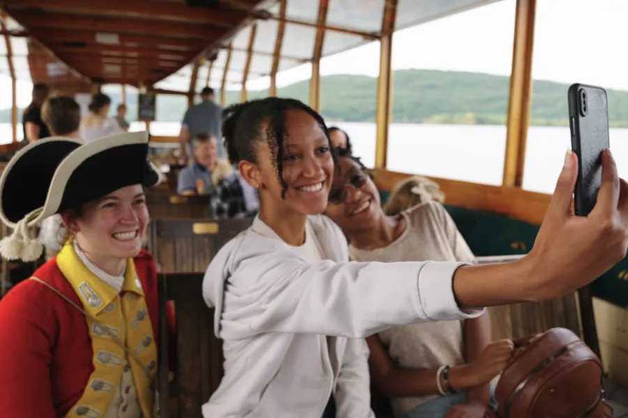A visitor takes a selfie with someone dressed as a Revolutionary War soldier