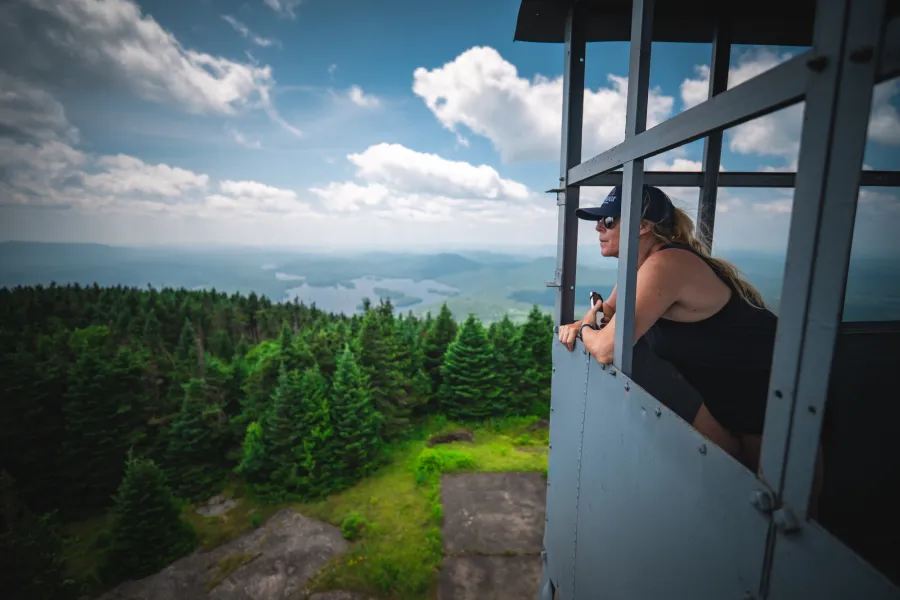 A women looks out from a fire tower