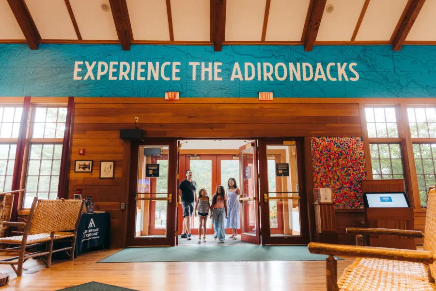 A family walks into the Adirondack Experience, Museum on Blue Mountain Lake