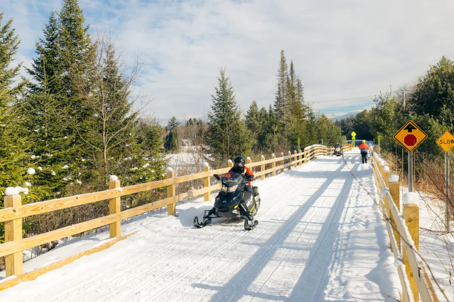 A snowmobiler and skier passing each other on the Rail Trail