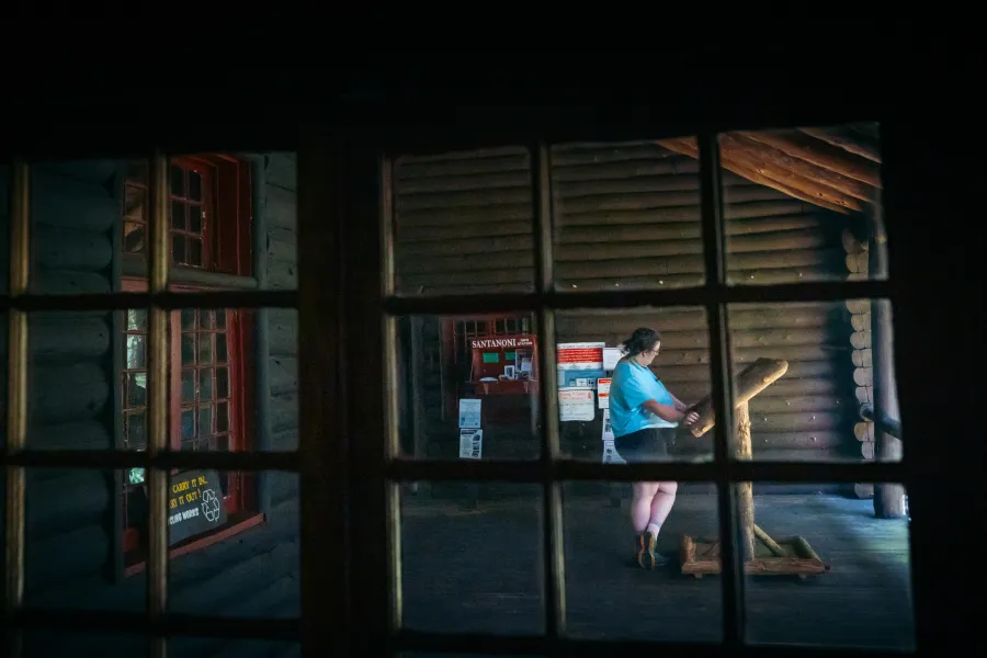 A visitor at Great Camp Santanoni reading an informational sign