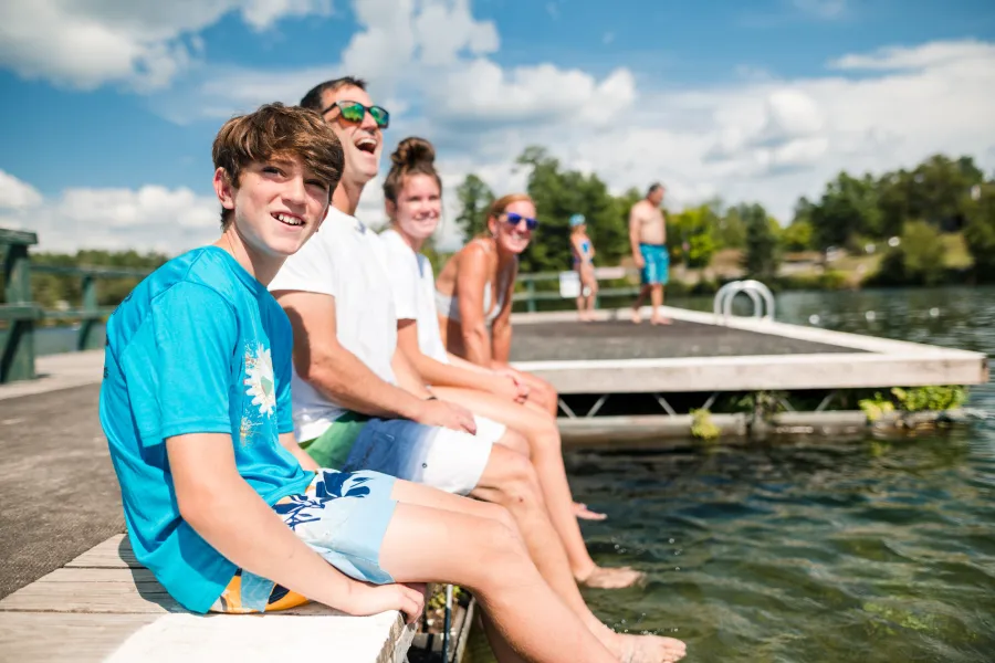 A family sitting on a dock on Mirror Lake in the summer