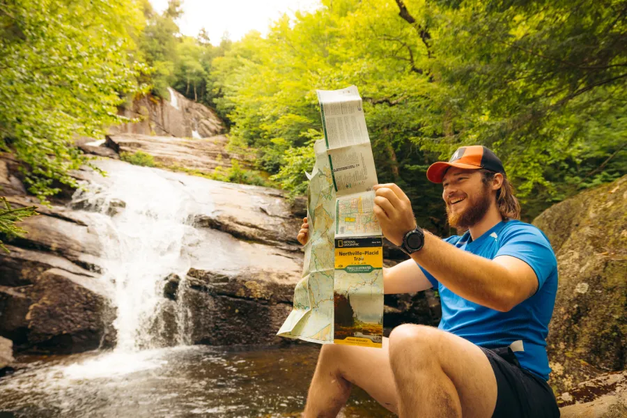 A hiker looking at a map by Wanika Falls