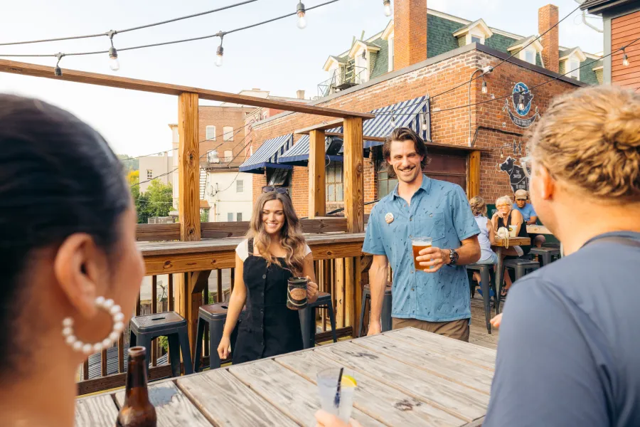 A couple friends enjoying beers on a patio
