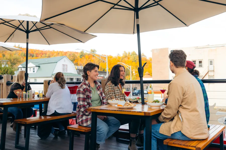 A young group of people sitting on a patio dining