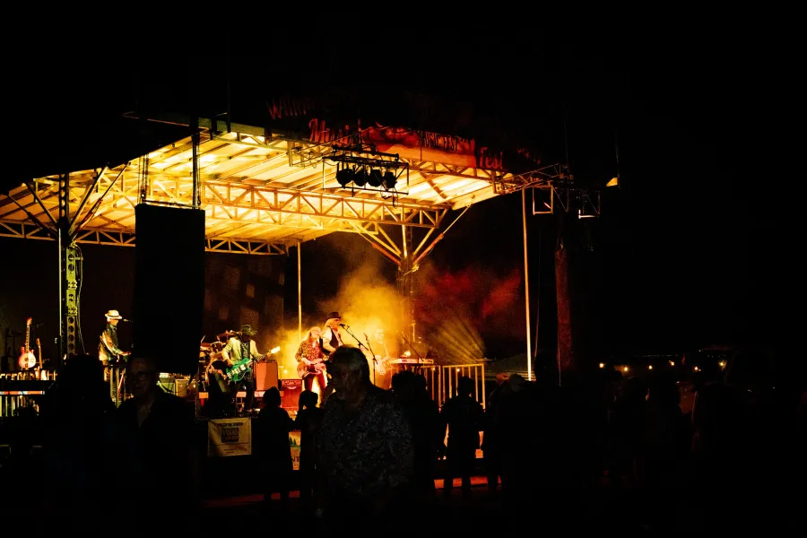 A rock band playing on stage at night