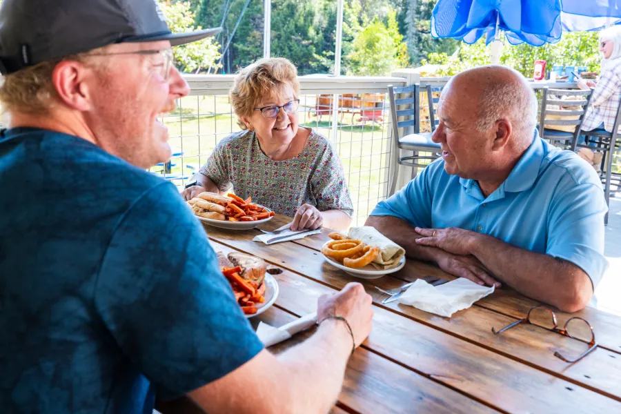 Three people dining outdoors on classic American eats
