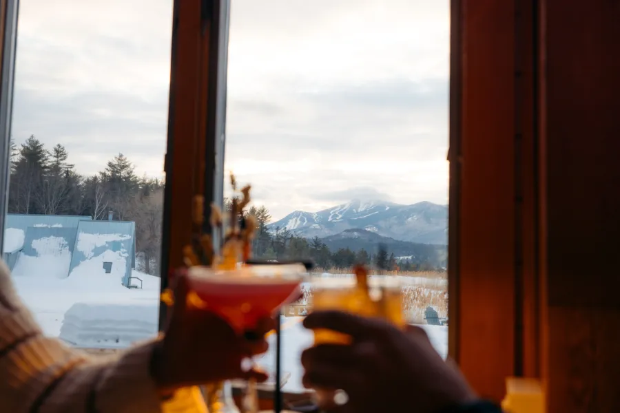 Drinks clinking in front of a view of Whiteface Mountain