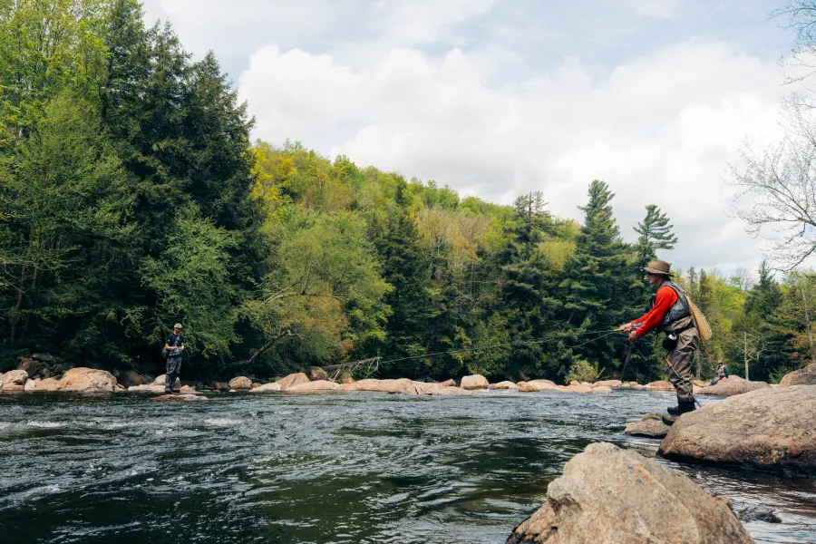 Someone fly fishing beside a river