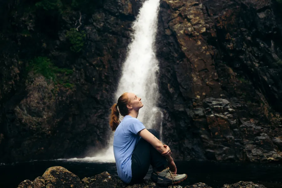 A woman in front of a waterfall