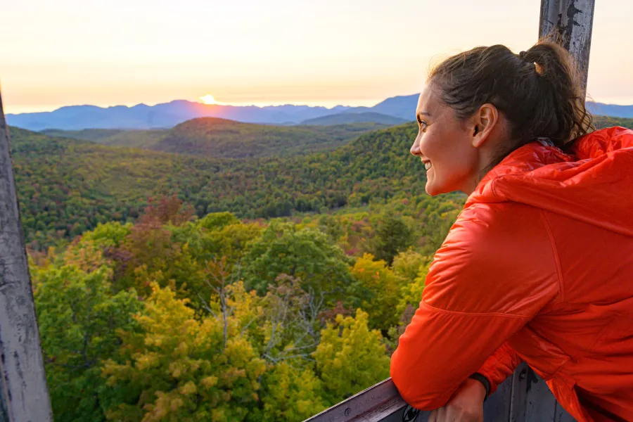 A hiker looking out at the views from a fire tower.