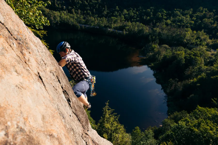 A climber leading up a prow above a pond