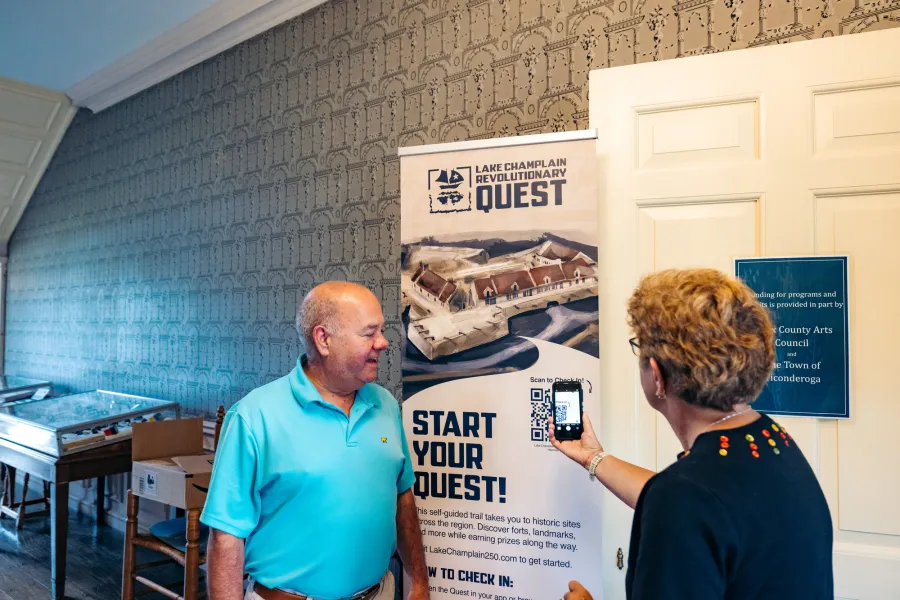 An older couple scanning a QR code for the Revolutionary Quest