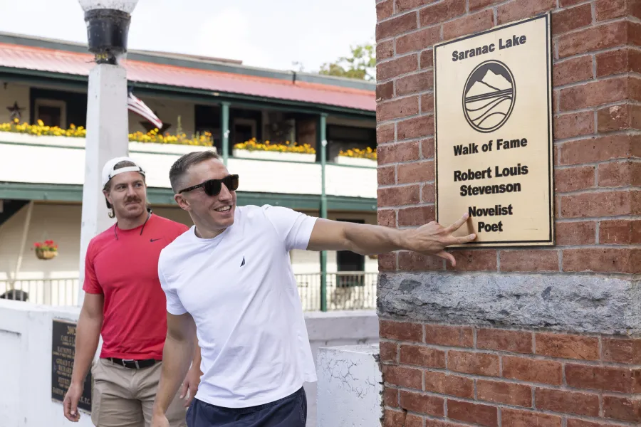 Two guys looking at signage on the Saranac Lake Walk of Fame