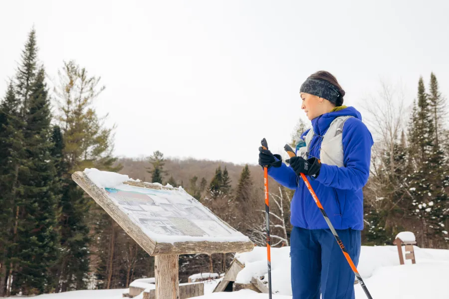A xc skier at an interpretive sign
