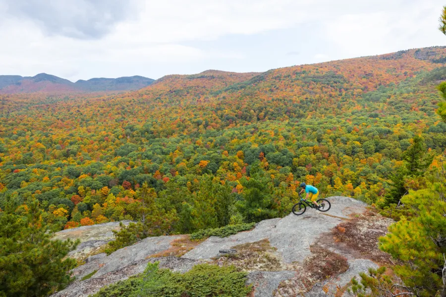 A mountain biker on an open summit area in the fall