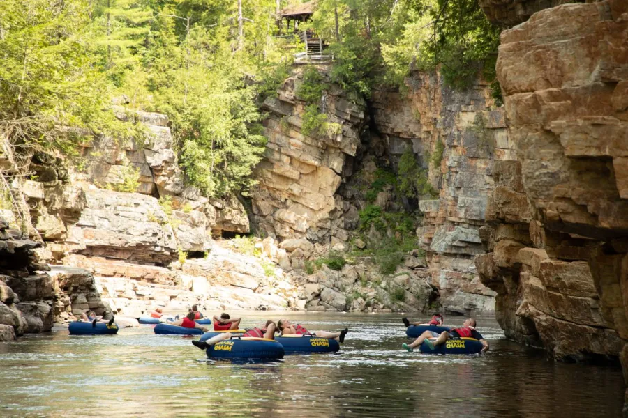 family floats through a river canyon on a sunny summer day. 