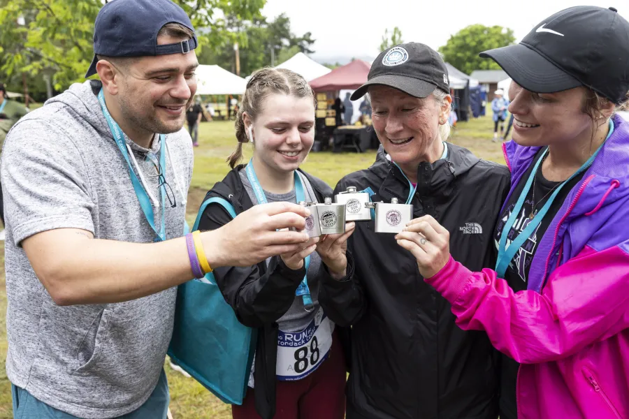 A group of runners cheers their flasks for a race. 