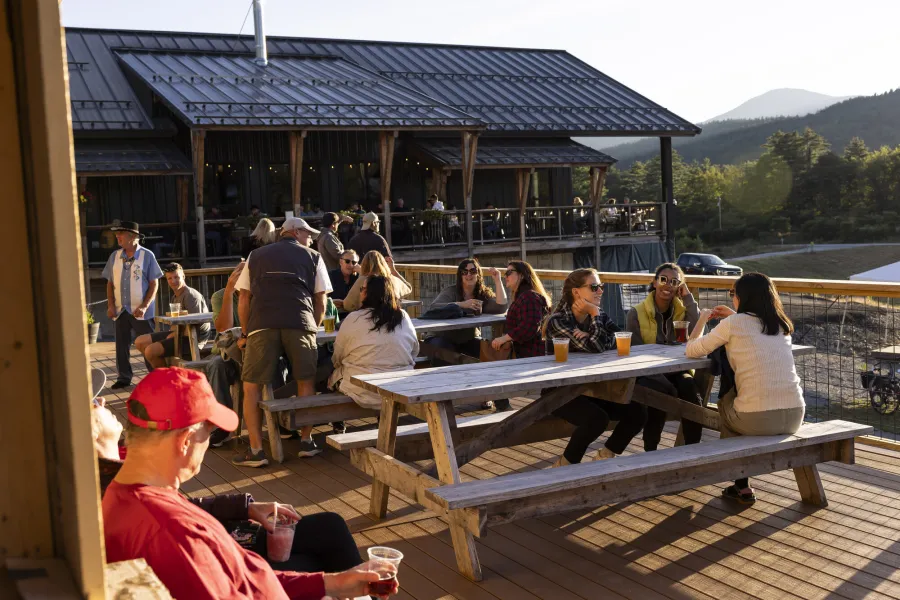 A group of people relax on a patio at a brewery. 