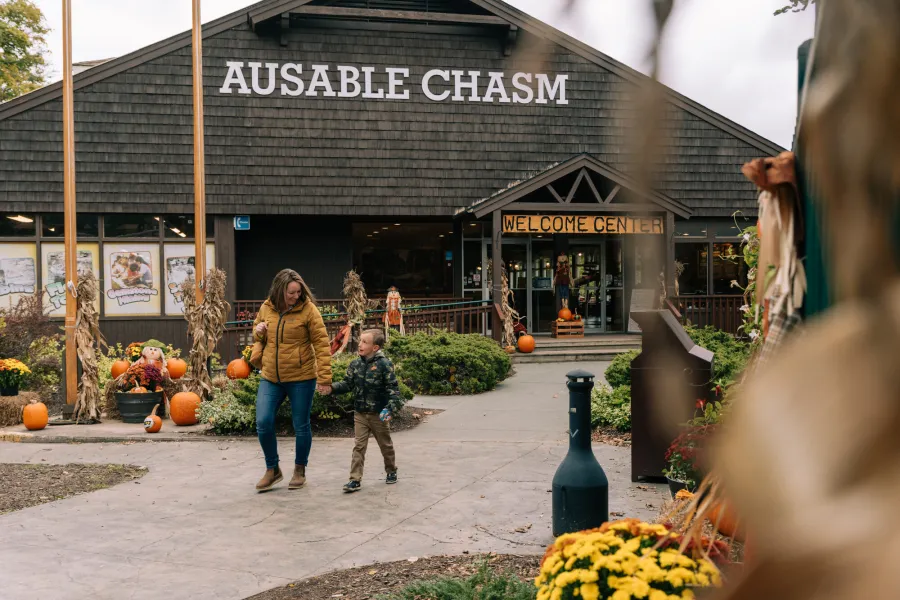 A woman and her son walk from a gift shop in the fall. 