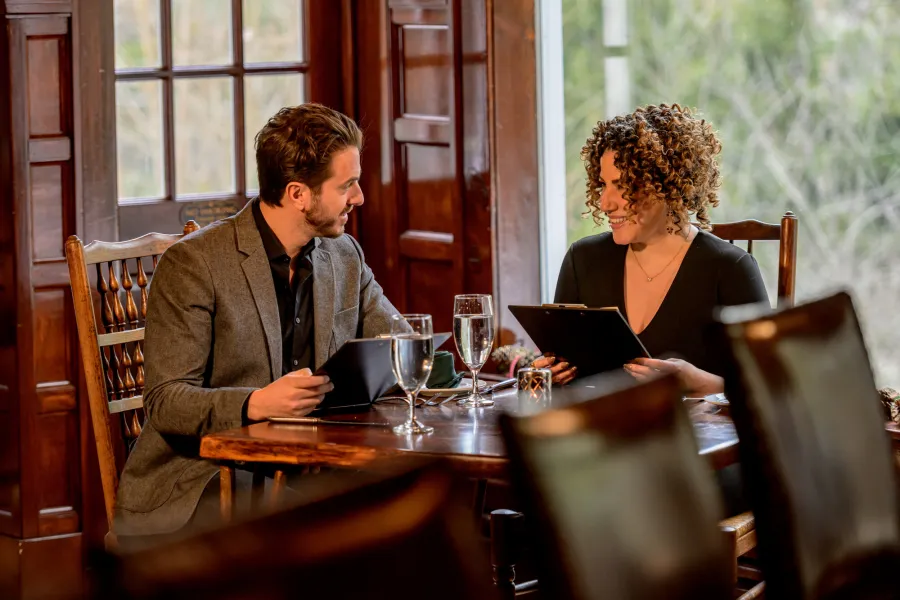 A man and woman have dinner at a fine dining restaurant. 