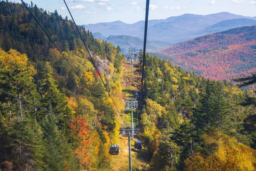 A gondola operates over a mountain in fall. 