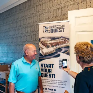 Two people signing up for the Revolutionary Quest via a QR code